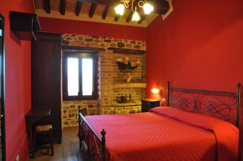 a red bedroom with a bed and a window at Agriturismo Arcobaleno della Torretta in Giano dellʼUmbria