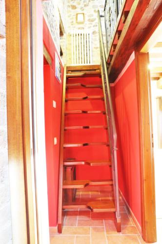 a staircase in a room with red walls at Agriturismo Arcobaleno della Torretta in Giano dellʼUmbria