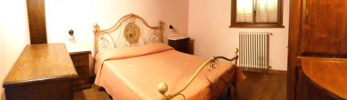 a bedroom with a bed with a wooden headboard at Agriturismo Arcobaleno della Torretta in Giano dellʼUmbria