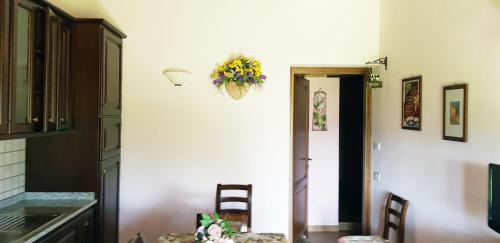 a kitchen with a table and a flower basket on the wall at Agriturismo Arcobaleno della Torretta in Giano dellʼUmbria