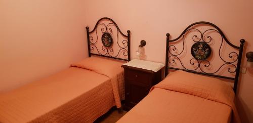 a bedroom with two beds and a nightstand with two twin beds at Agriturismo Arcobaleno della Torretta in Giano dellʼUmbria