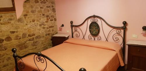 a bedroom with a bed and a stone wall at Agriturismo Arcobaleno della Torretta in Giano dellʼUmbria