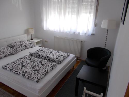 - une chambre avec un lit, une chaise et une fenêtre dans l'établissement Albatros A1, à Zagreb