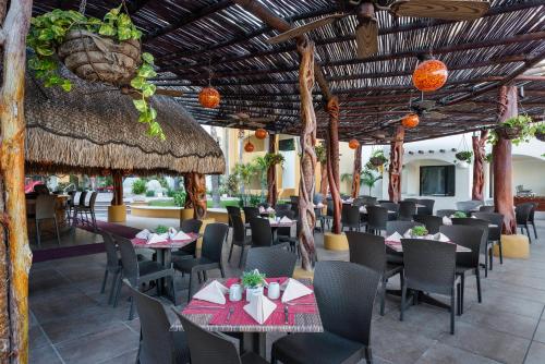 ein Restaurant mit Tischen und Stühlen und einer strohgedeckten Decke in der Unterkunft Marina Fiesta Resort & Spa, A La Carte All Inclusive Optional in Cabo San Lucas