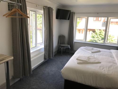 a hotel room with a bed and two windows at The Lake House in Plymouth