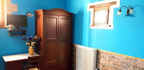 a blue room with a cabinet and a window at Agriturismo Arcobaleno della Torretta in Giano dellʼUmbria