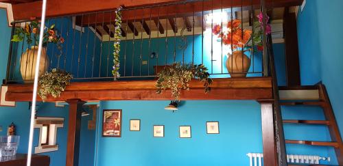 a room with a blue wall with vases and a staircase at Agriturismo Arcobaleno della Torretta in Giano dellʼUmbria