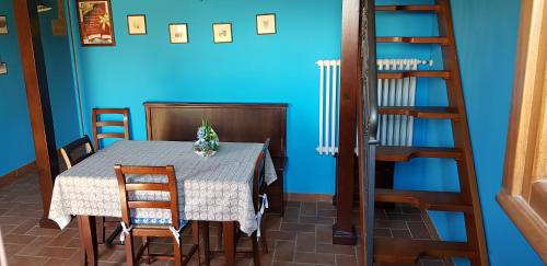 a dining room with a table and a blue wall at Agriturismo Arcobaleno della Torretta in Giano dellʼUmbria