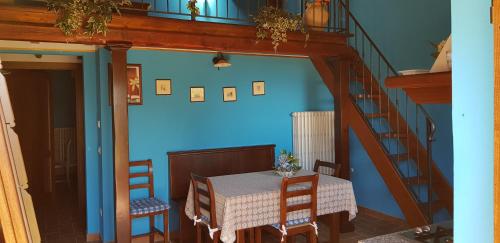 a dining room with a table and a blue wall at Agriturismo Arcobaleno della Torretta in Giano dellʼUmbria