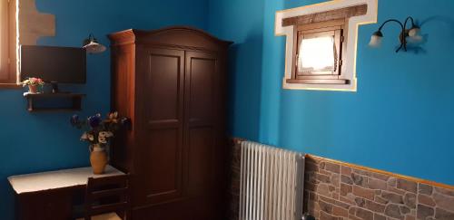 a blue room with a cabinet and a window at Agriturismo Arcobaleno della Torretta in Giano dellʼUmbria