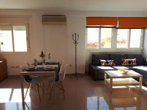 a living room with a couch and a table at La casa de Blanca. Coqueto piso céntrico y cerca de todo in Almería