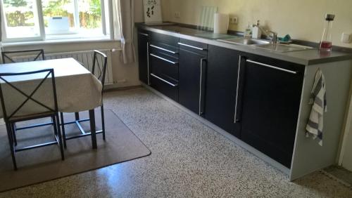 a kitchen with black cabinets and a sink and a table at Vila Adelaide in Brtníky