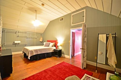 a bedroom with a bed and a red rug at Historic Apartment in the Heart of Christiansted in Christiansted