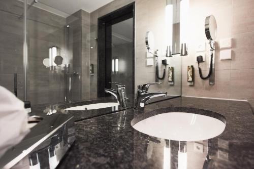 a bathroom with two sinks and two mirrors at Gasthof Linde in Albstadt