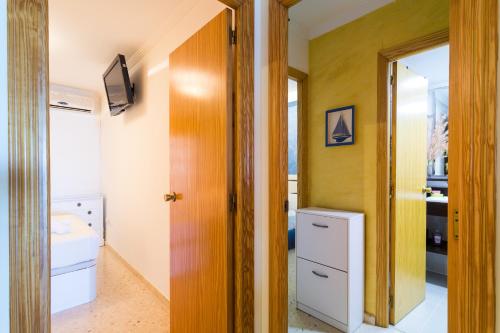 a bathroom with a toilet and a sink and a mirror at ApartUP Saplaya Harbour in Alboraya