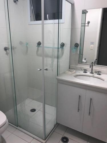 y baño con ducha acristalada y lavamanos. en Condominio Reserva da Mata - Riviera de São Lourenço, en Riviera de São Lourenço