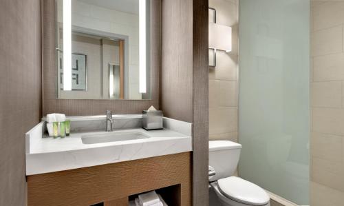 a bathroom with a sink and a toilet and a mirror at The STRAT Hotel, Casino & Tower in Las Vegas