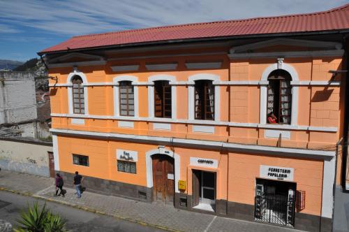un edificio naranja con gente caminando delante de él en Casa Bella Vista, en Quito