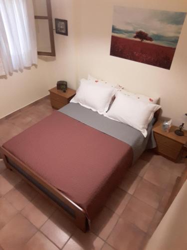 a bed with two pillows on it in a room at Cute apartments with romantic view in Pyrgadikia