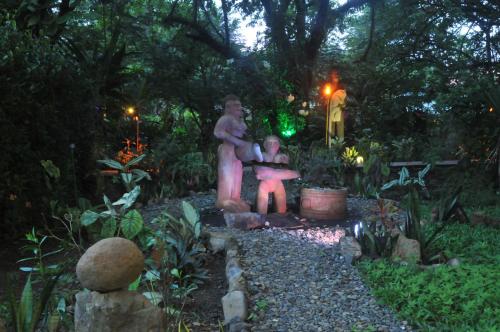 a statue of a man and a woman in a garden at Las Brisas del Sur in Ojochal