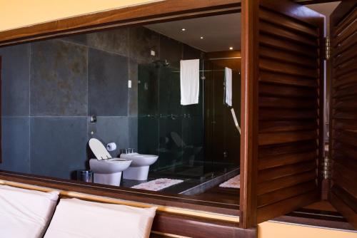 a bathroom with two toilets and a large glass window at Casa da Estrela in Barra do Cunhau