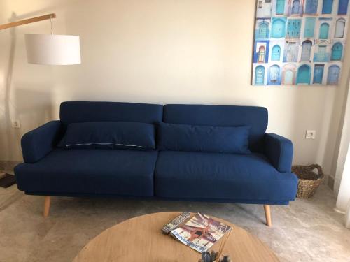 a blue couch in a living room with a table at Puerto Fino Apartamentos in Almerimar