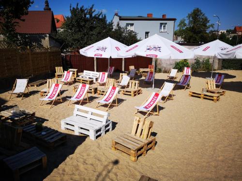a group of chairs and umbrellas on a beach at Hotel Gryf in Kościerzyna