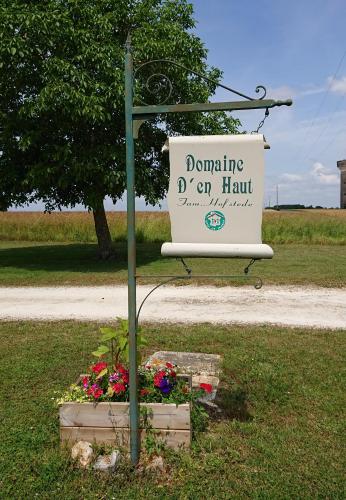a sign on a pole in the grass with flowers at domaine d'en Haut in Lochy