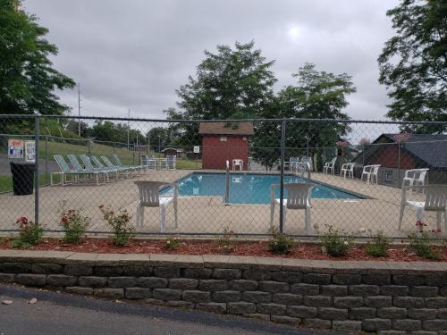 a swimming pool with chairs and a fence at Woodside Dells Hotel & Suites in Wisconsin Dells