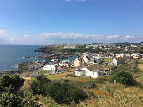 a small town on a hill next to the ocean at The Waterfront in Portpatrick