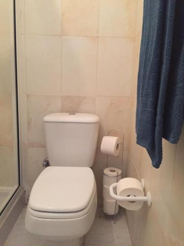 a bathroom with a white toilet and a blue towel at Casa Namaste Bed & Breakfast/Appartement in Praia