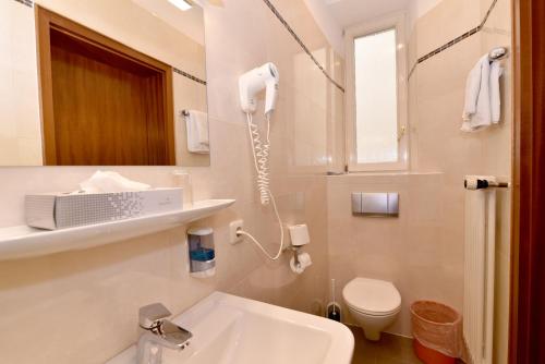 a bathroom with a white sink and a phone on the wall at Hotel Römerhof in Baden-Baden