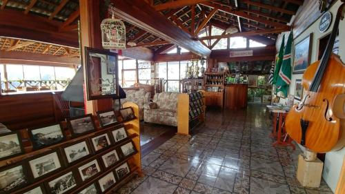 a room with a living room with a guitar in it at Pousada dos Esquilos in Campos do Jordão