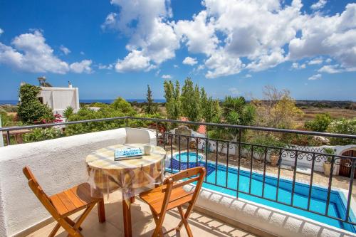 a balcony with a table and chairs and a pool at B&B & Apartments The Four Elements in Lachania
