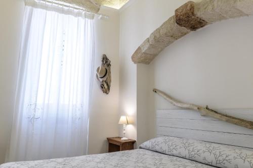 a bedroom with a bed and a large window at CASA MELIO' in Polignano a Mare