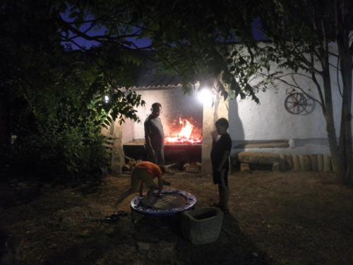 a group of people standing around a fire at night at Casa Rural El Llano Quintanilla in Yecla