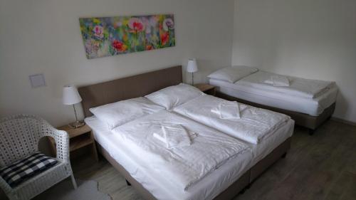 a hotel room with two beds and a chair at Apartmány Nova Lake in Nová Pec
