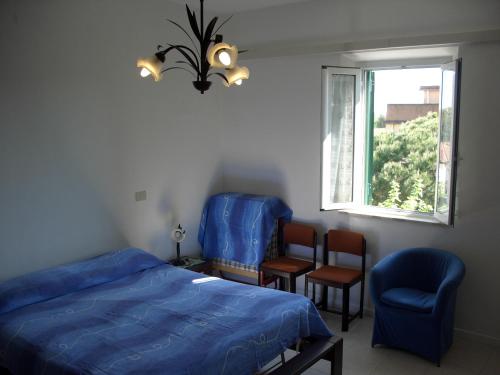 a bedroom with a bed and two chairs and a window at Blu Mariner in Vada
