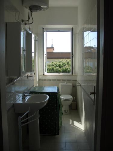a bathroom with a sink and a toilet and a window at Blu Mariner in Vada