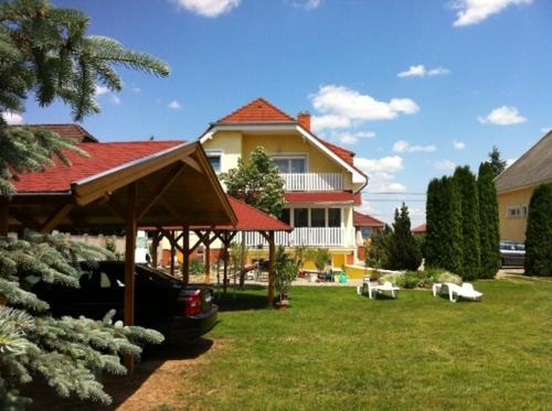 a house with a car parked in front of a yard at Györgyi Haus in Bük