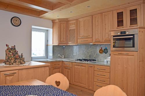 a kitchen with wooden cabinets and a stove top oven at La Suite in Candide