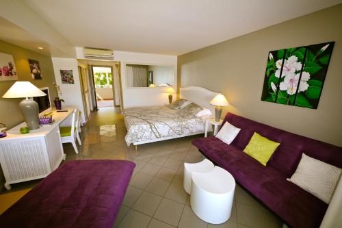 uma sala de estar com um sofá e uma cama em Résidence de La Vieille Tour em Le Gosier