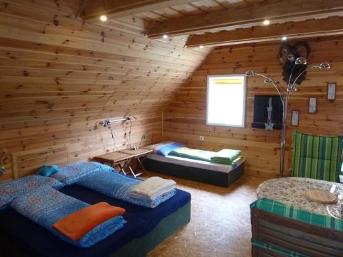 um quarto com duas camas num chalé de madeira em Vesnická usedlost em Český Rudolec