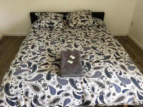 a bed with a black and white comforter with a heart on it at Maison entière au pied des vignes in Lussac