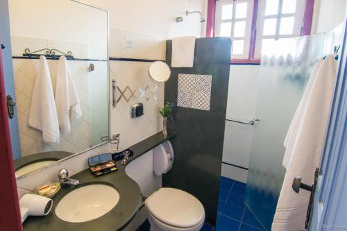 uma casa de banho com um WC, um lavatório e um chuveiro em Pousada Bárbara Bela em Tiradentes