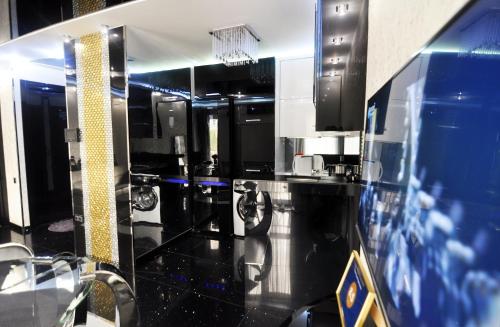 een grote keuken met zwarte en blauwe aanrechtbladen bij Hotel Chanel Apartments in Tbilisi City