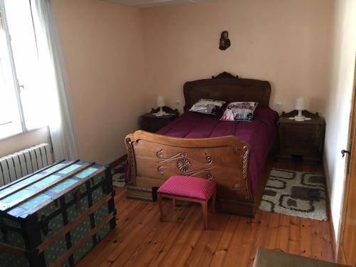 Un dormitorio con una cama con sábanas moradas y una silla en Vivienda vacacional casa pereira luarca, en Cabornas