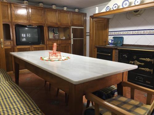 una cocina con una mesa con una silla. en Vivienda vacacional casa pereira luarca, en Cabornas