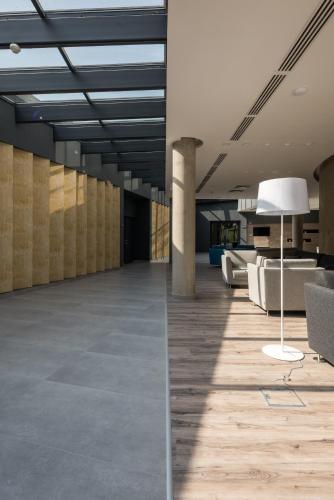 an empty lobby with a couch and a lamp at Várda Sport Hotel in Kisvárda