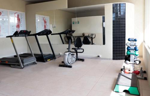 a gym with treadmills and ellipticals in a room at Limeira Suítes in Limeira